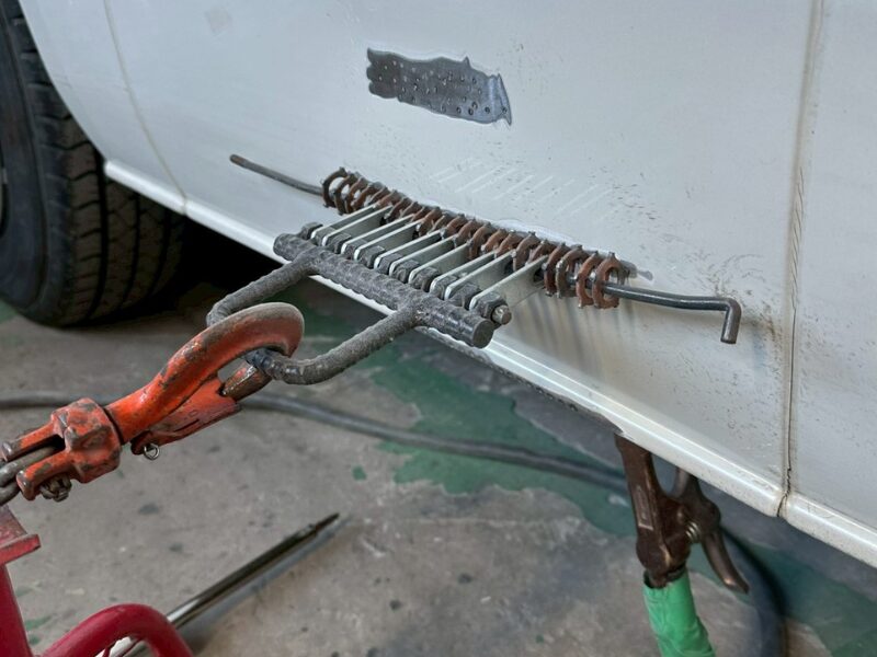 スライドハンマーを使用してサイドパネルを引き出している修正工程