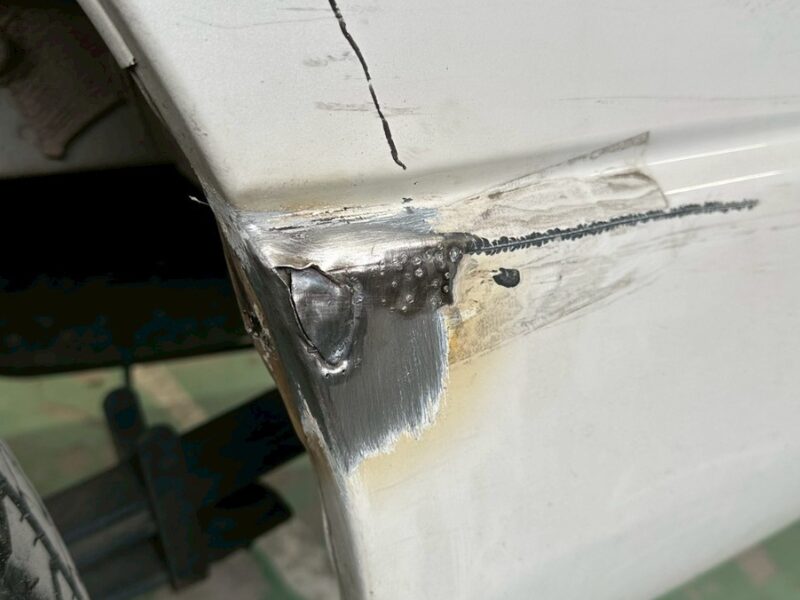 リアフェンダー角部が大きく変形し、金属が露出している損傷状態